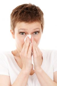 mujer sonándose la nariz alergias catarros