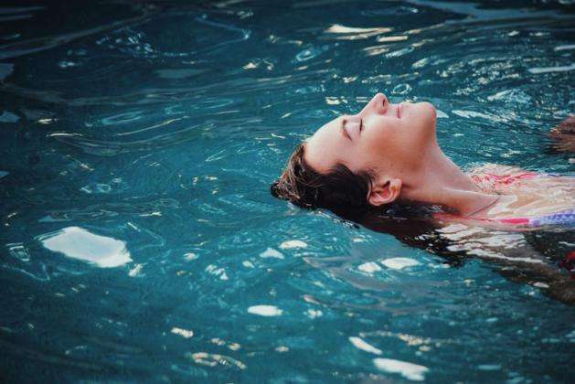 mujer boca arriba en el agua piscina o mar, puede nadar o hacer ejercicio