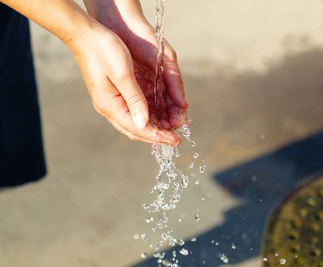 manos cogiendo agua para refrescarse del calor