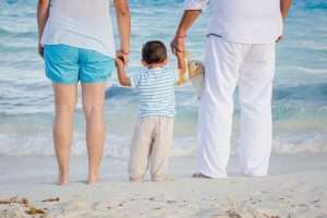 padres con hijo en la playa mirando al mar