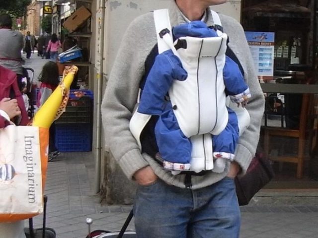 padre llevando a su bebé en una mochila portabebés