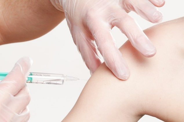pinchazo de vacuna en brazo