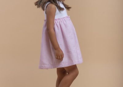 Vestido niña combinado de algodón blanco y falda rosa a rayas, tallas 3 a 10 años (Laranjinha, 38 €).