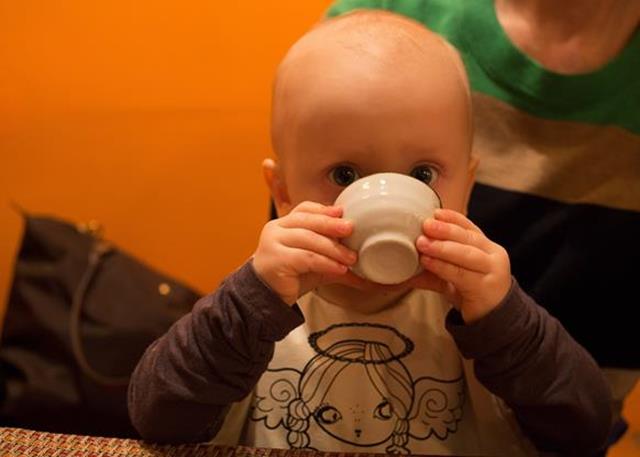 bebé bebe agua en taza